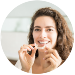 Mujer sonriendo mientras utiliza un alineador dental transparente, parte de los tratamientos de ortodoncia en Serviprodent, Valdemorillo