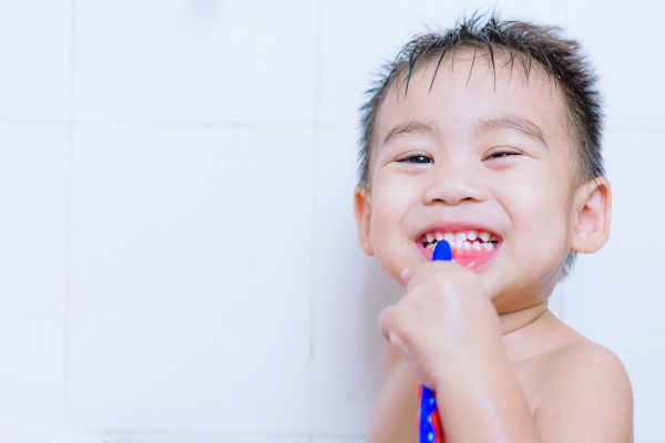 Diversión y aprendizaje: Cómo hacer del cepillado un hábito diario Niño cepillándose los dientes mientras disfruta de su rutina de baño.