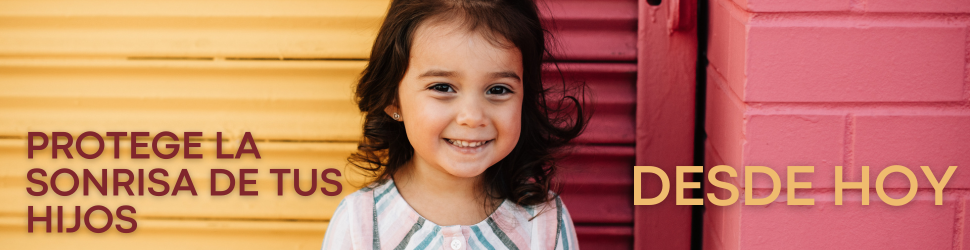 La importancia de una sonrisa sana desde la infancia. Niña pequeña sonriendo frente a una pared de colores.